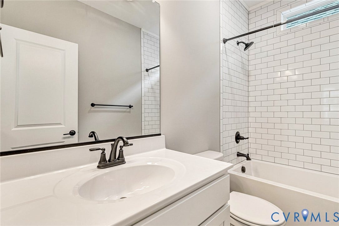 310 E 33rd Street, Swansboro West, Richmond, VA 23224 White subway tile shower surround with a built-in tub and dark-bronze fixtures