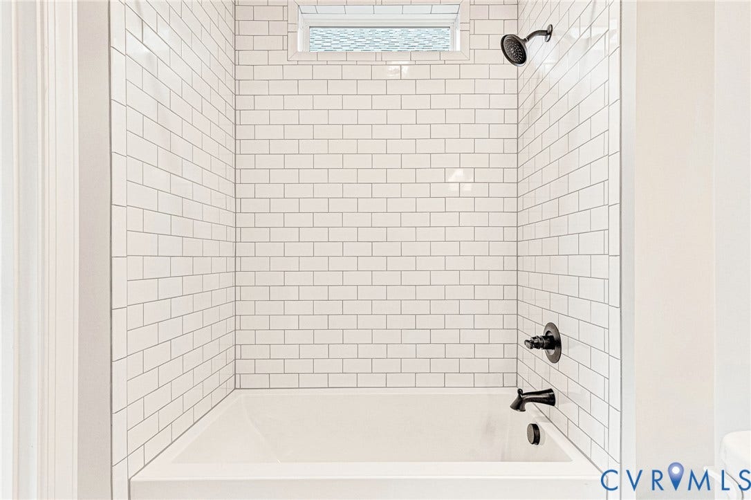 310 E 33rd Street, Swansboro West, Richmond, VA 23224 Subway tile shower surround with a built-in tub, transom window, and matte black fixtures