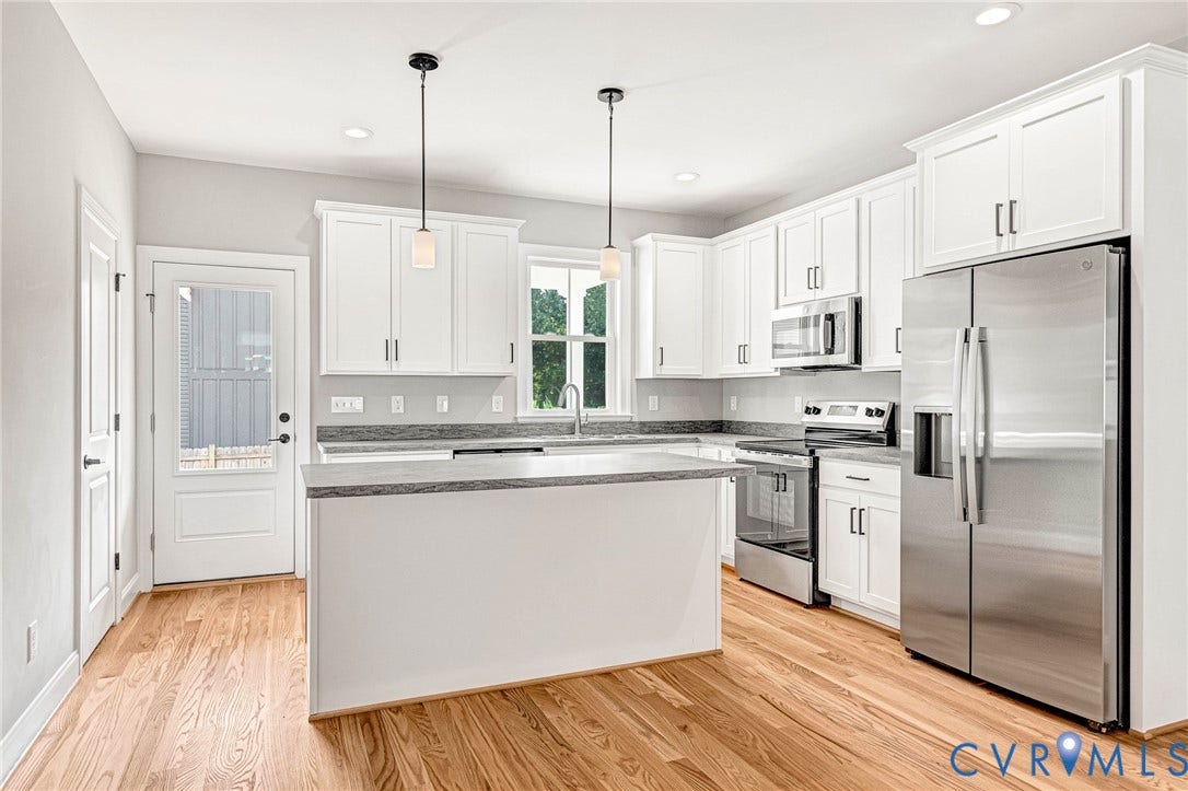 310 E 33rd Street, Swansboro West, Richmond, VA 23224 Hardwood flooring, white cabinetry, stainless steel appliances, kitchen island, and recessed lighting