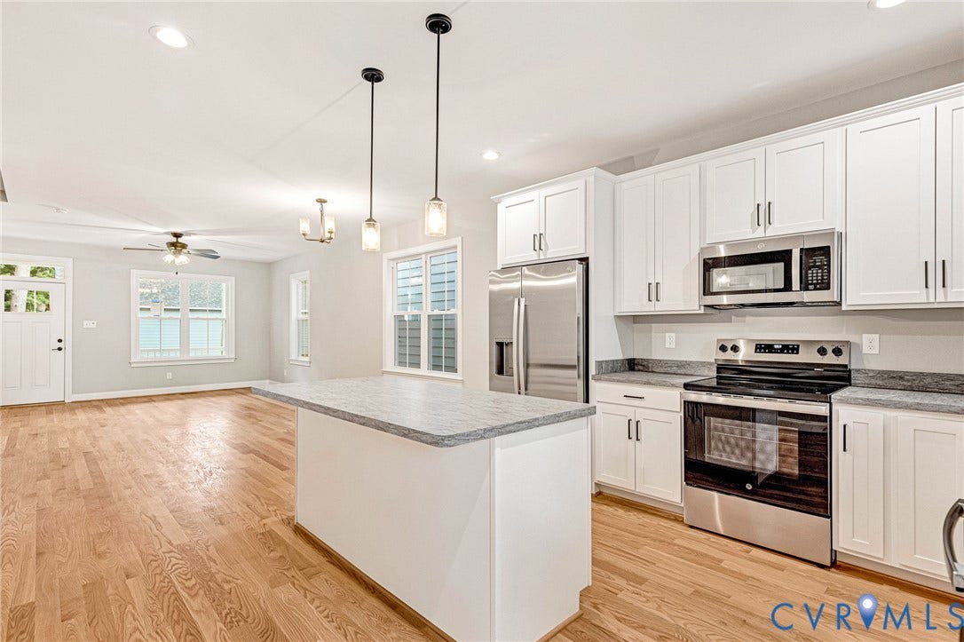 308 E 33rd Street, Swansboro West, Richmond, VA 23224 Wood-finish flooring throughout, white shaker-style cabinetry, stainless steel appliances, granite countertops, and a kitchen island with pendant lighting