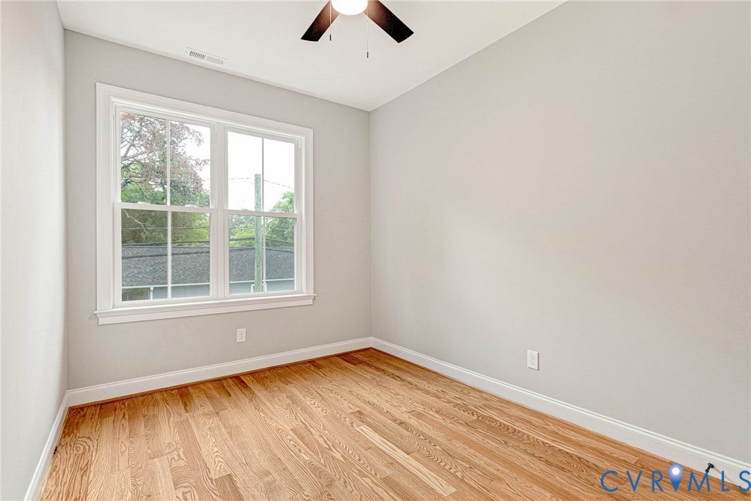 308 E 33rd Street, Swansboro West, Richmond, VA 23224 Hardwood flooring, painted walls, ceiling fan, and a double-hung window with white trim