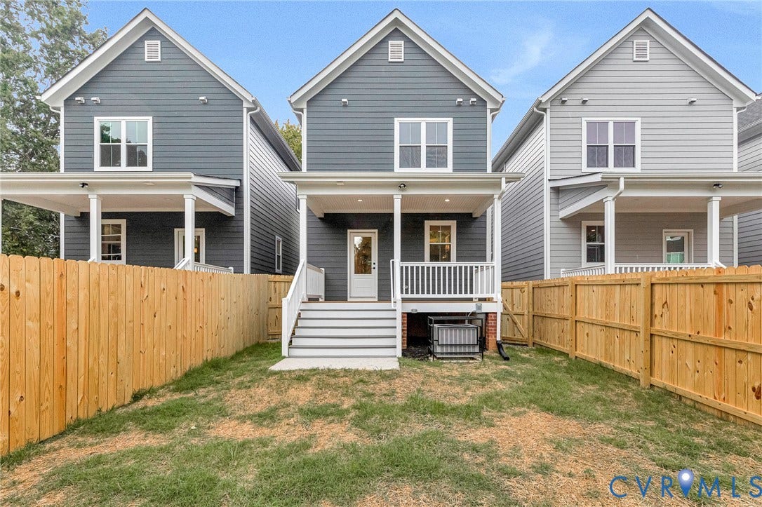 308 E 33rd Street, Swansboro West, Richmond, VA 23224 Rear exterior featuring a covered porch, white railings, and a fenced yard with a wood privacy fence
