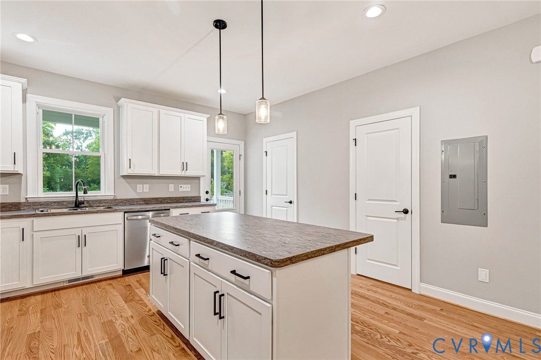 308 E 33rd Street, Swansboro West, Richmond, VA 23224 Kitchen with white cabinetry, a center island, pendant lighting, stainless steel dishwasher, and wood-finish flooring