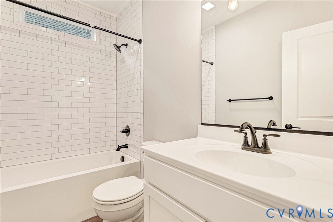 308 E 33rd Street, Swansboro West, Richmond, VA 23224 White subway tile shower surround with a fixed showerhead and tub filler