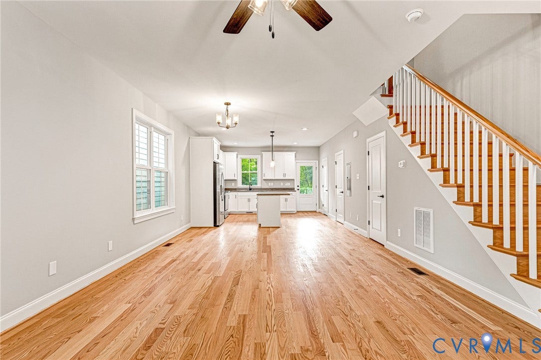 308 E 33rd Street, Swansboro West, Richmond, VA 23224 Hardwood flooring, white shaker cabinetry, stainless steel appliances, central island, and a wooden staircase