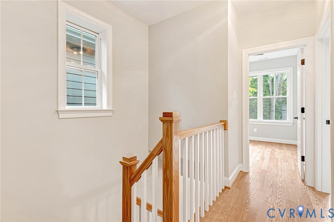 308 E 33rd Street, Swansboro West, Richmond, VA 23224 Bright hallway featuring gleaming wood-finish flooring, white painted walls, and a classic wooden staircase with white spindle railing