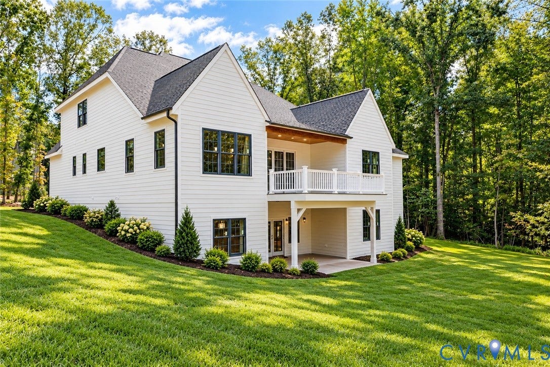 2695 High Bank Place, Powhatan, VA 23139 White siding exterior with dark-framed windows, a second-story balcony with white railings, and a covered ground-level patio