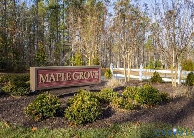 2695 High Bank Place, Powhatan, VA 23139 Maple Grove community signage featuring a red and tan sign, surrounded by landscaped shrubbery and trees, with a white fence in the background