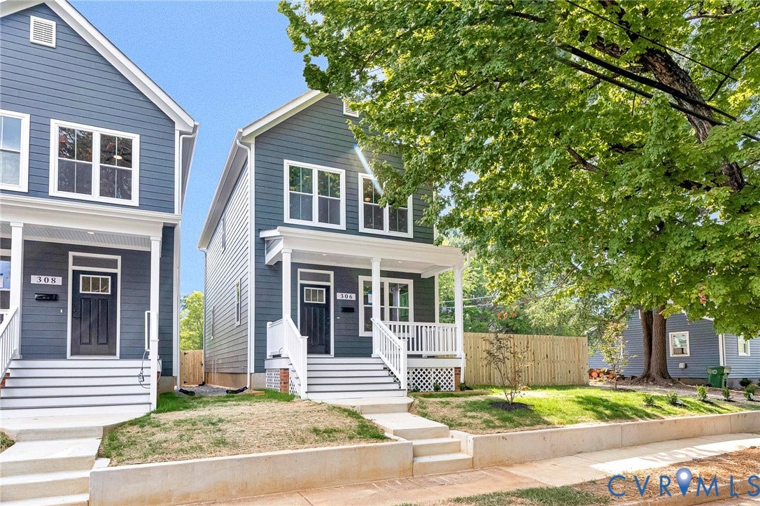306 E 33rd Street, Swansboro West, Richmond, VA 23224 Modern facade with blue siding, white window trim, a covered porch, white railings, and a manicured front lawn