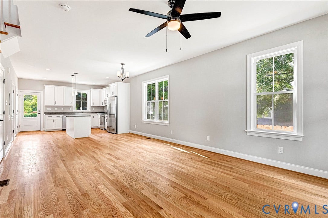 306 E 33rd Street, Swansboro West, Richmond, VA 23224 Hardwood flooring throughout, white kitchen cabinetry, stainless steel appliances, kitchen island, and ceiling fan with integrated lighting