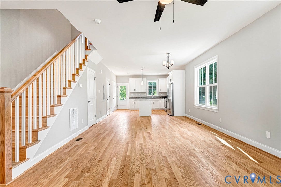 306 E 33rd Street, Swansboro West, Richmond, VA 23224 Hardwood flooring, white painted walls, white kitchen cabinetry, stainless steel appliances, and a central island