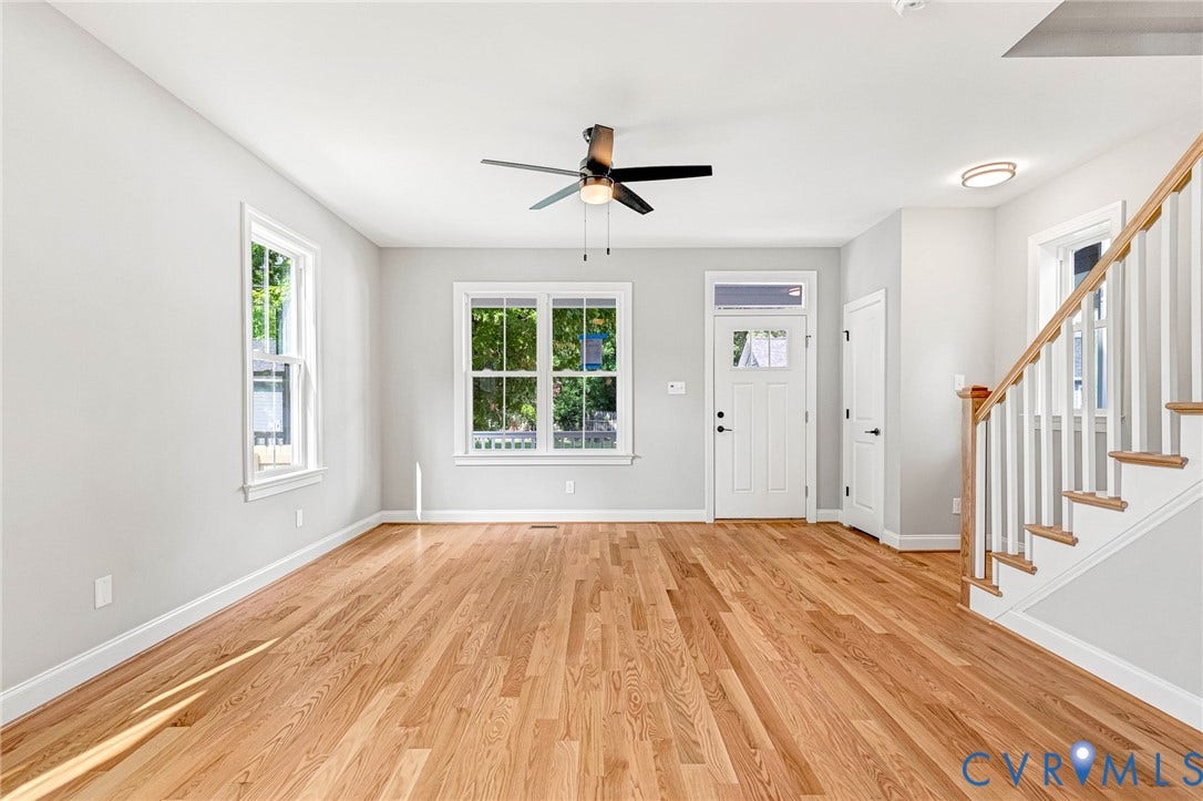 306 E 33rd Street, Swansboro West, Richmond, VA 23224 Hardwood flooring, multiple windows, a ceiling fan, a front entry door with a transom, and a staircase with white balusters