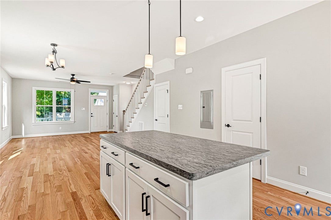 306 E 33rd Street, Swansboro West, Richmond, VA 23224 Wood-finish flooring, white shaker cabinetry, gray stone countertop, and two pendant lights