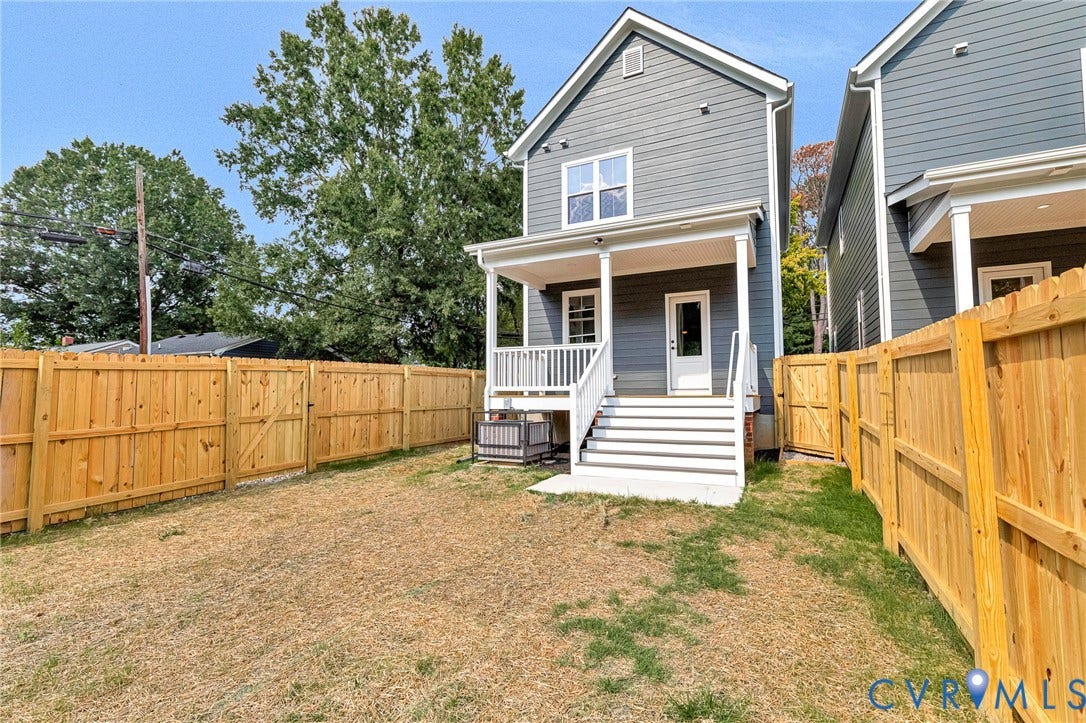 306 E 33rd Street, Swansboro West, Richmond, VA 23224 Rear exterior with gray siding, a covered porch with white columns, and a private wooden fence