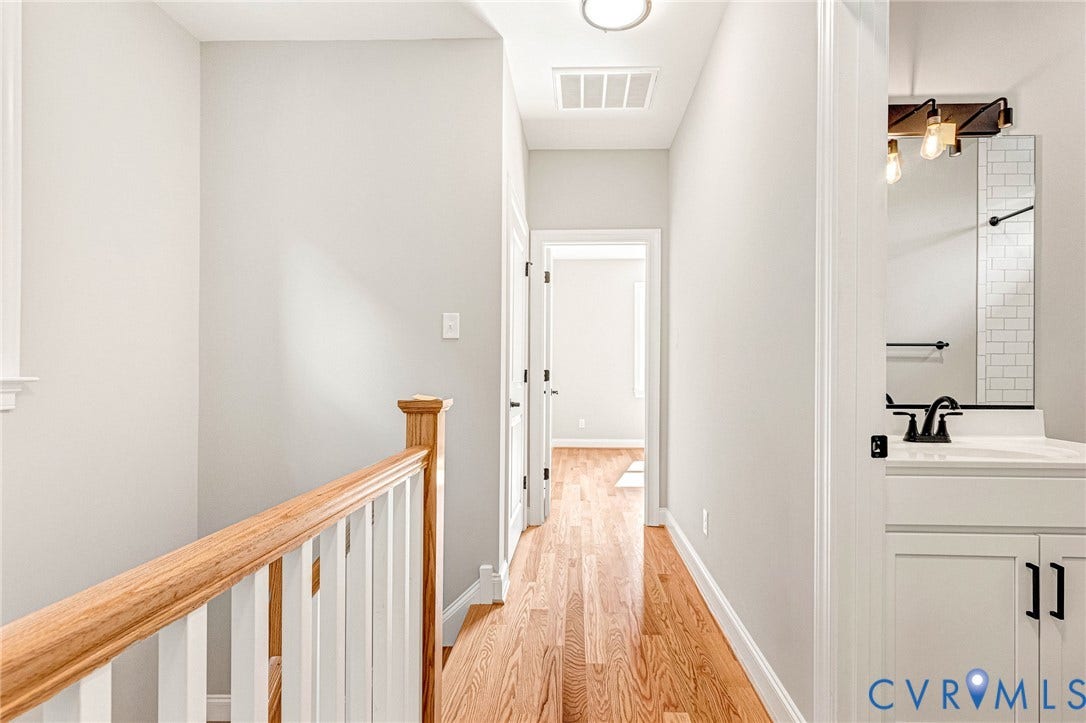 306 E 33rd Street, Swansboro West, Richmond, VA 23224 Hardwood flooring, painted white railing with natural wood-finish top, recessed lighting, white vanity with stone-finish countertop, matte black faucet, and subway tile backsplash