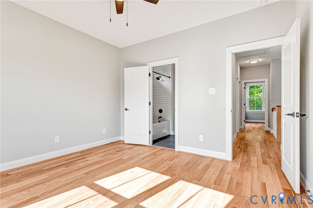306 E 33rd Street, Swansboro West, Richmond, VA 23224 Wood-finish flooring, white paneled doors, ceiling fan, and light gray wall paint