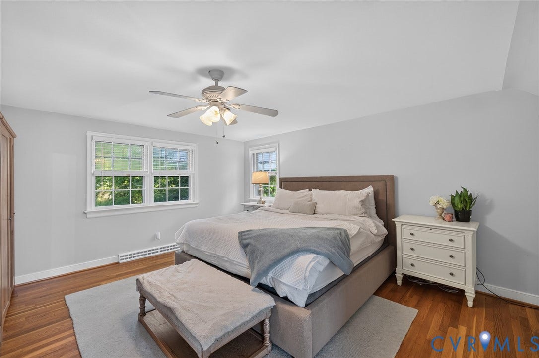 Wood-finish flooring, white window frames, ceiling fan with integrated lighting, built-in wooden wardrobe