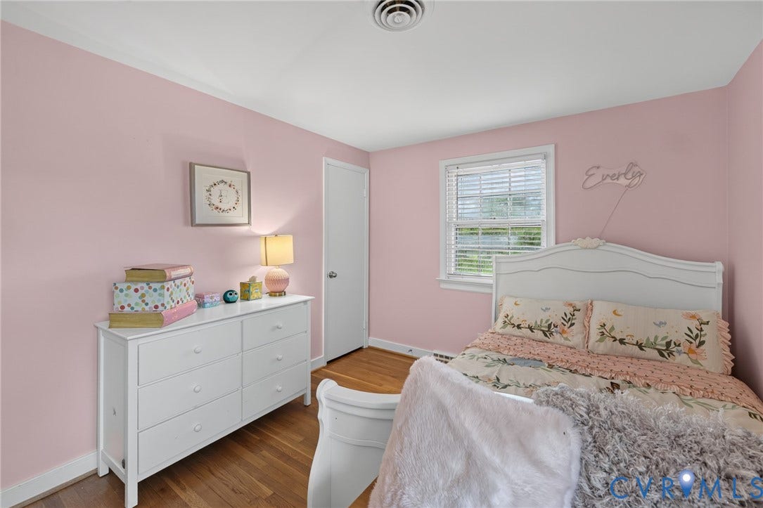 Hardwood flooring, painted walls, white trim, and a window with blinds