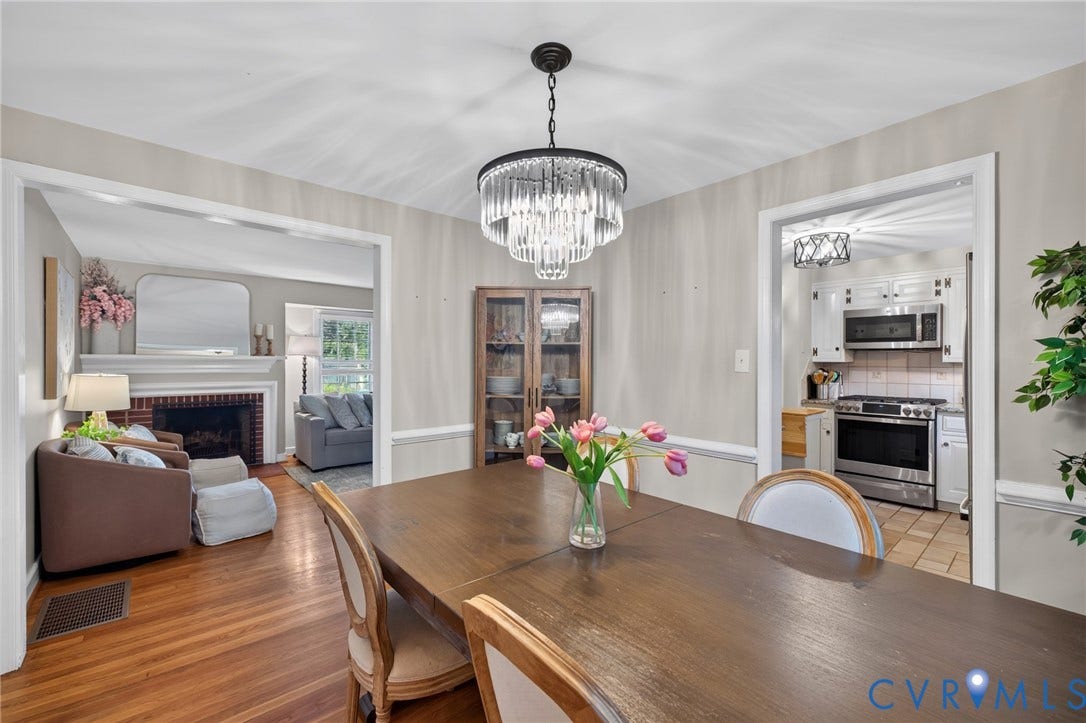 Dining area with wood-finish flooring, a tiered crystal chandelier, and a built-in display cabinet