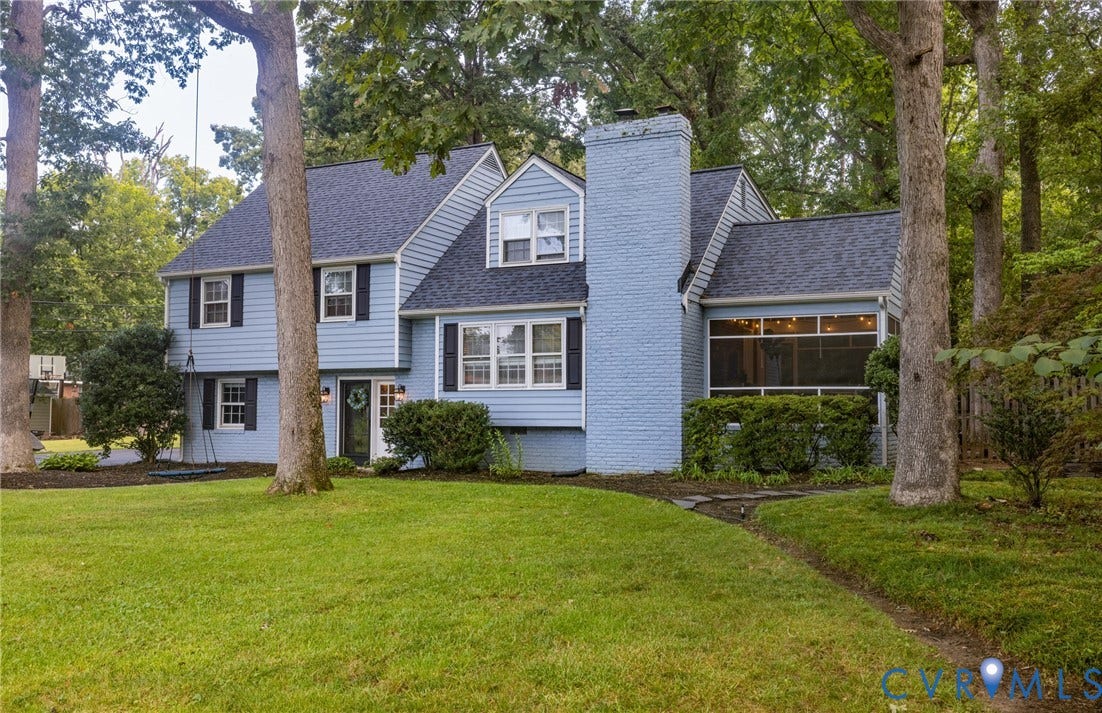 Light blue siding exterior with dark shutters, prominent brick chimney, and screened-in porch