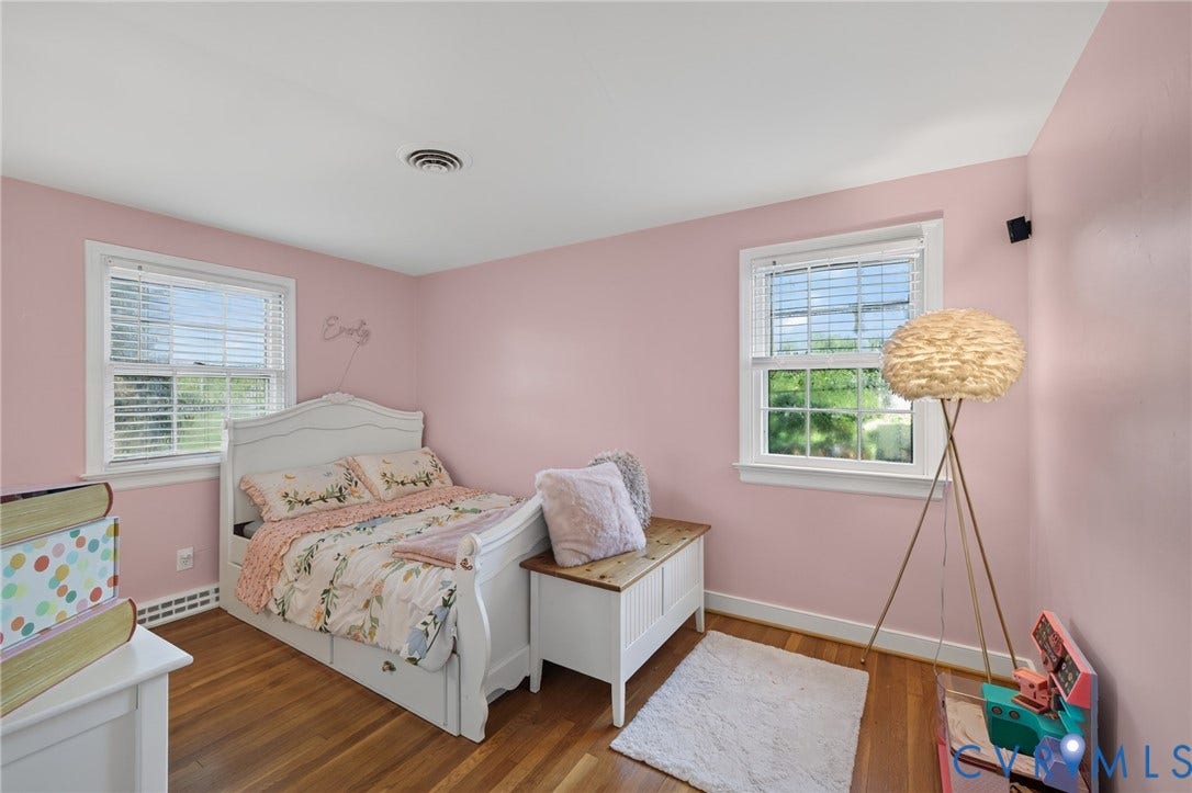Wood-finish flooring with white trim and a neutral painted ceiling
