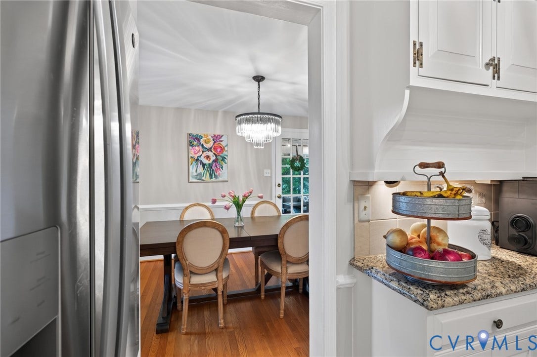 Kitchen with granite countertops, tile backsplash, white cabinetry, and recessed lighting