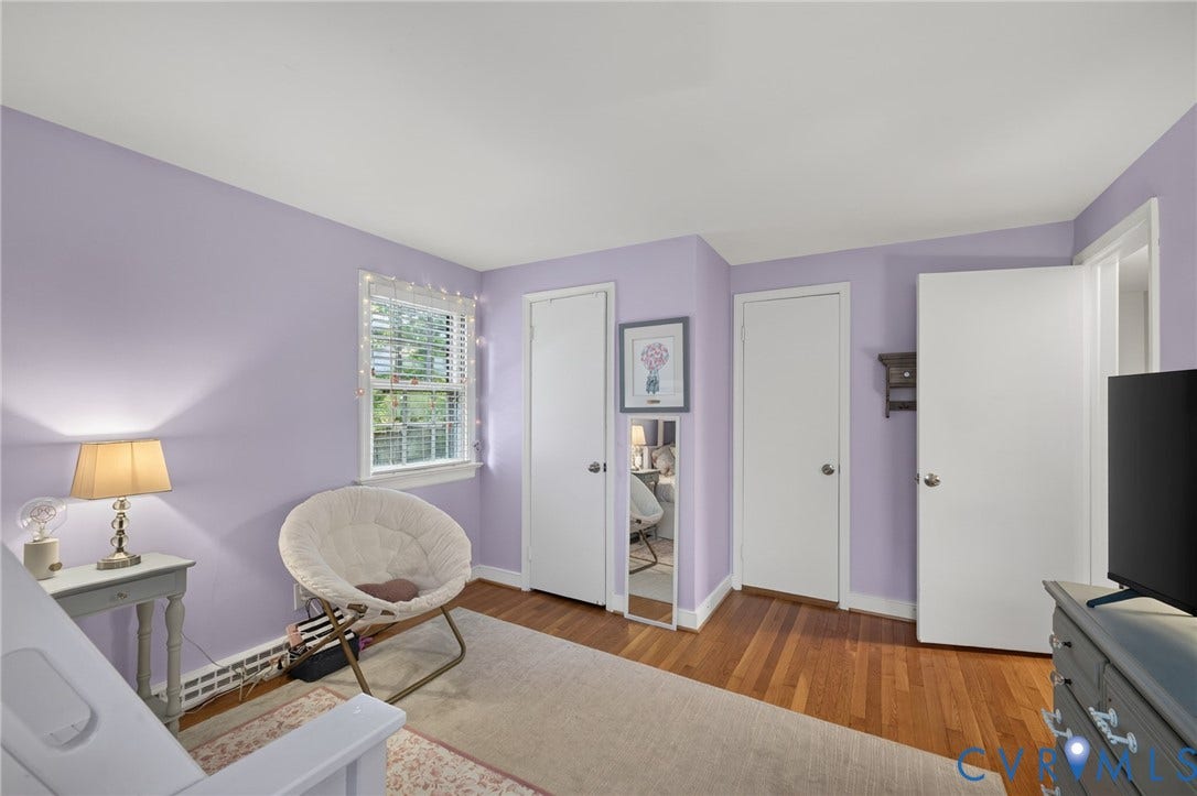 Hardwood flooring, painted walls, white trim, and a window with blinds