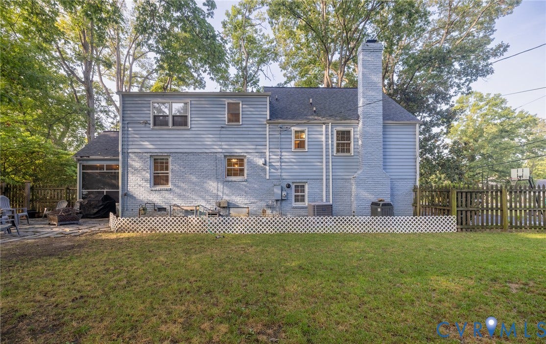 Expansive lawn with a wooden privacy fence and a lattice-skirted patio