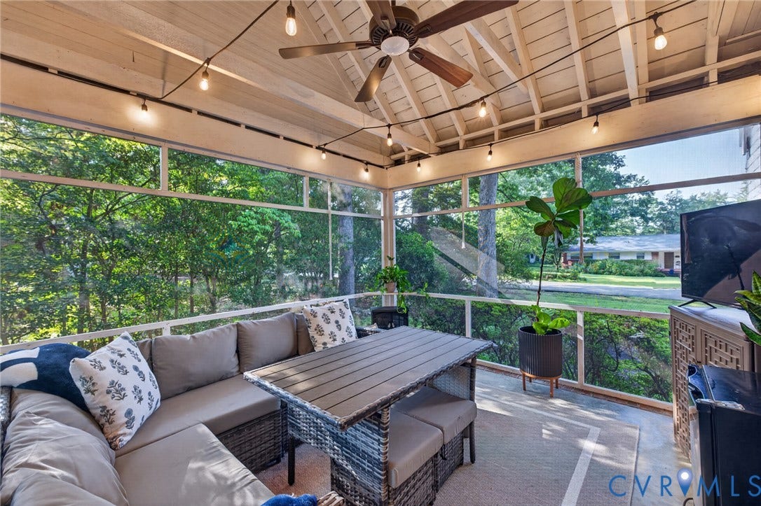 Screened porch featuring a vaulted ceiling, exposed rafters, ceiling fan, string lighting, and ample natural light