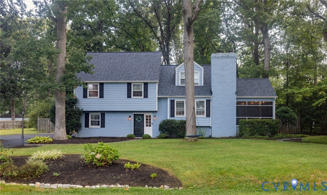 Two-story residence featuring light blue siding, black shutters, and an asphalt shingle roof