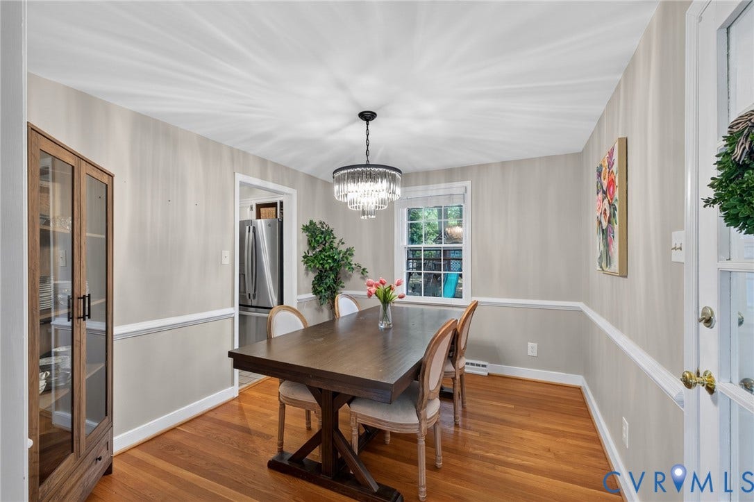 Hardwood flooring, crown molding, chair rail molding, clear glass-panel door, and a built-in display cabinet