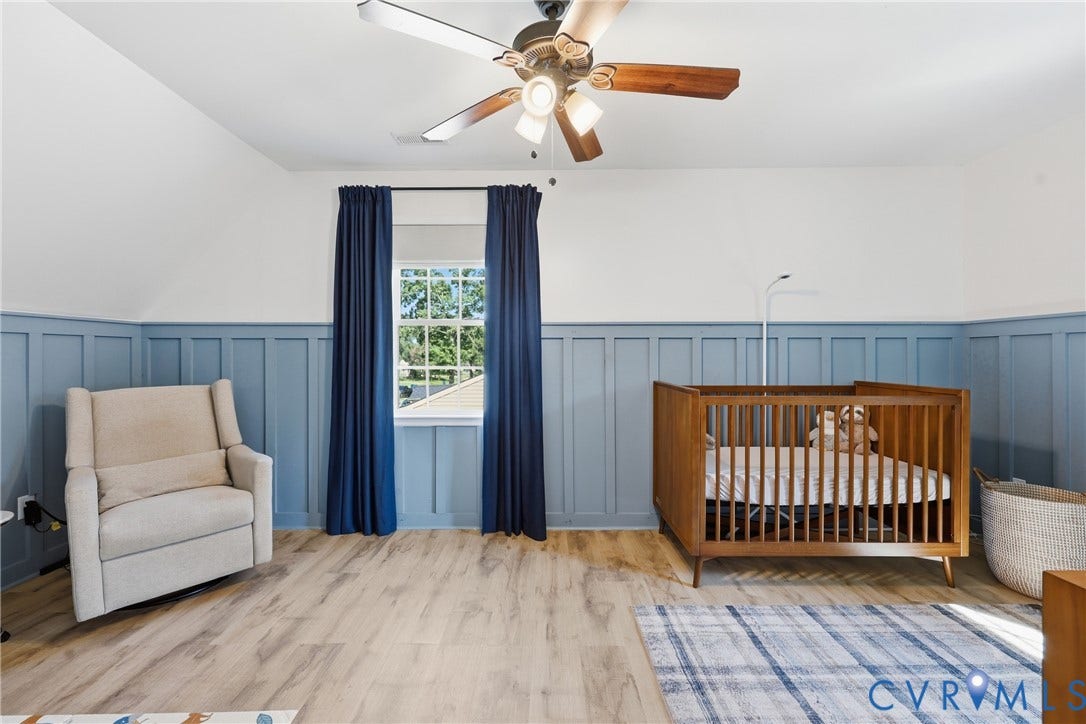 9349 Shiloh Drive, Chesterfield, VA 23237 Wood-finish flooring, accent board and batten paneling, ceiling fan with integrated lighting, and a window with natural light