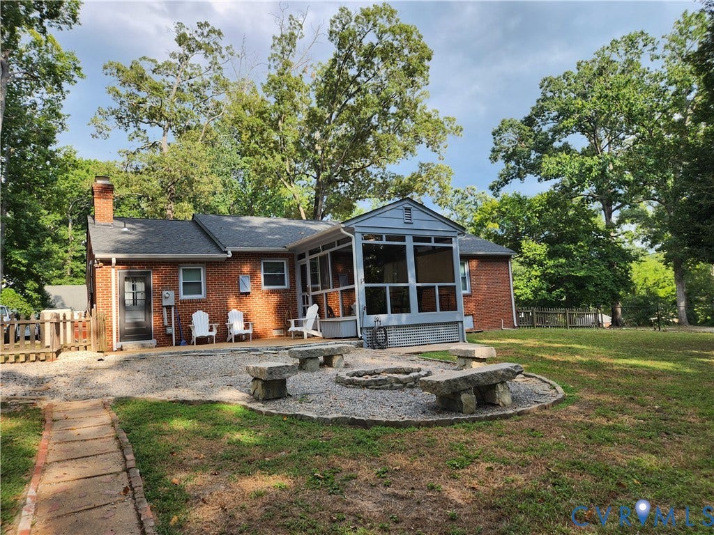 Brick exterior featuring a screened porch and a patio
