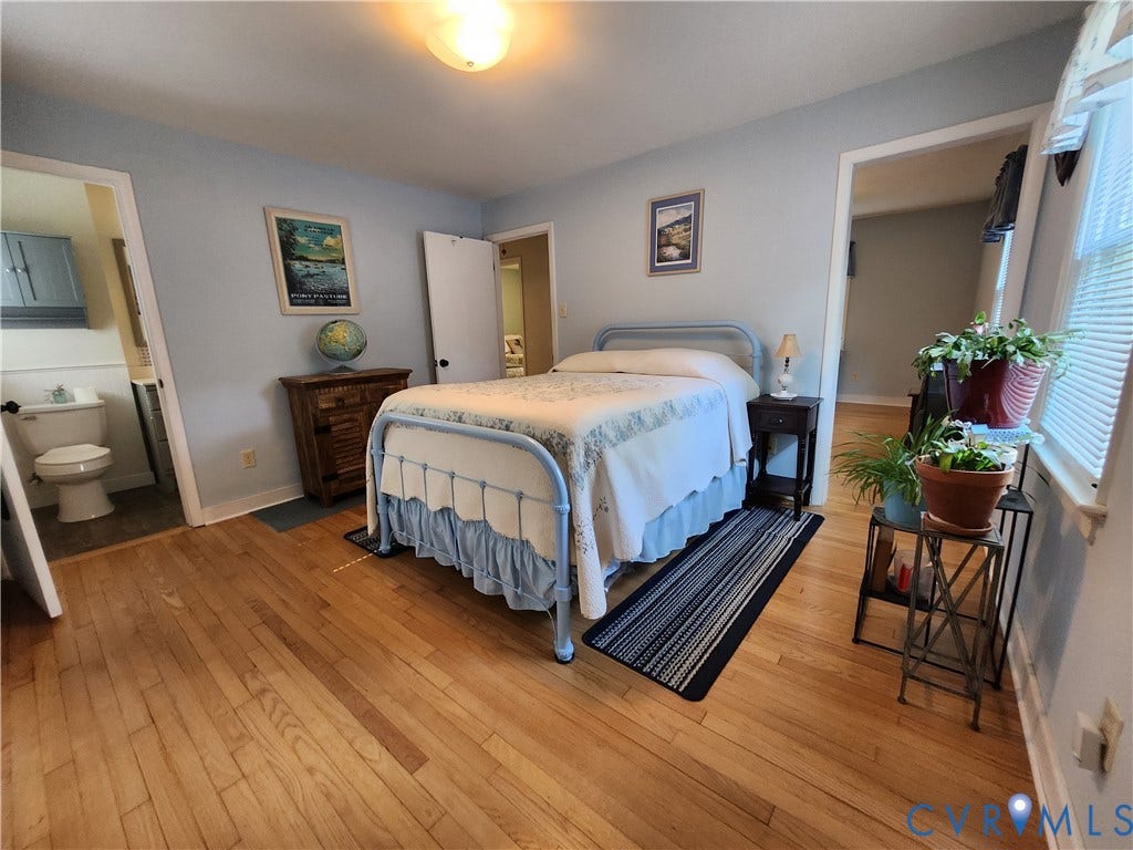 Hardwood flooring, light blue wall paint, single window, flush-mount ceiling light