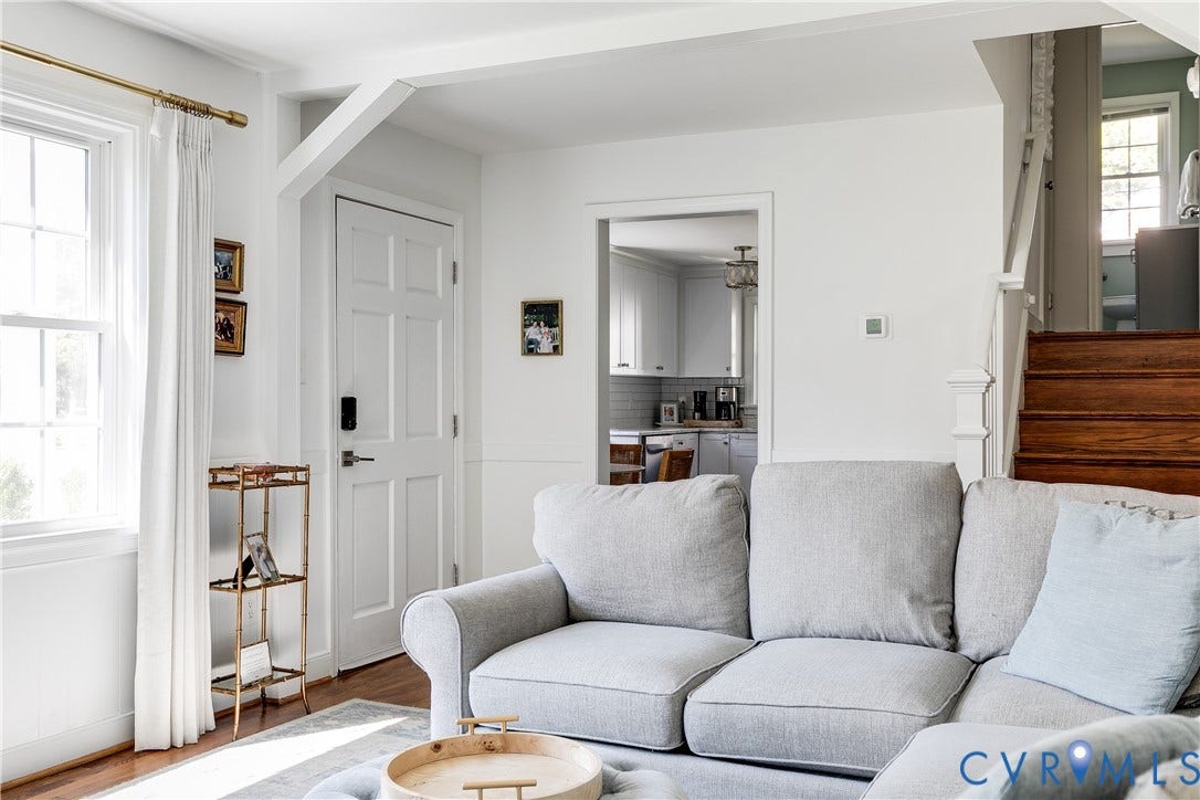 Hardwood flooring, painted paneled interior door, and window with natural light