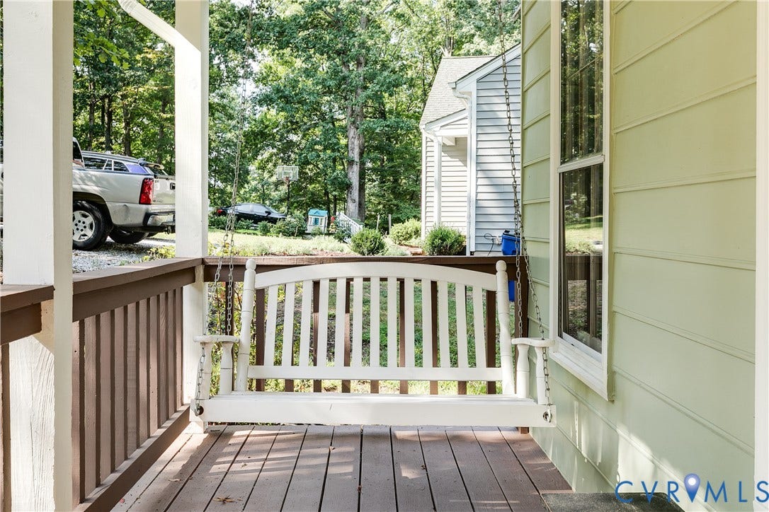 1506 Porters Mill Terrace, Smoketree South, Midlothian, VA 23114 Covered porch featuring a white porch swing, wood-finish flooring, and a railing with vertical balusters
