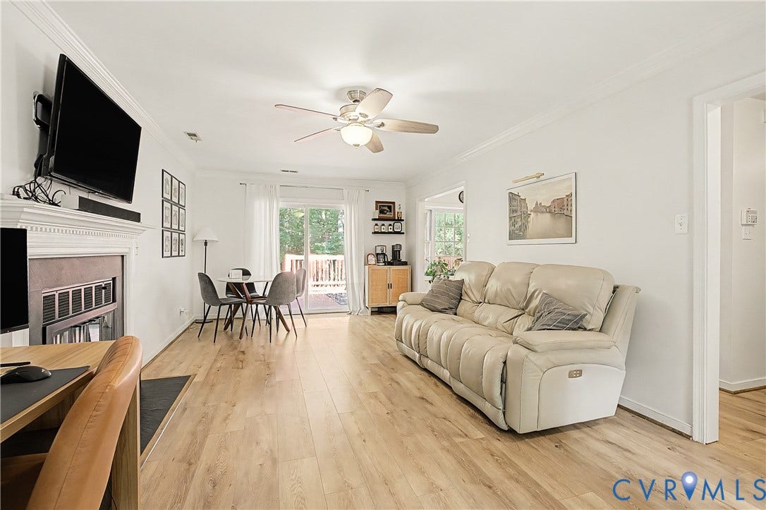 1506 Porters Mill Terrace, Smoketree South, Midlothian, VA 23114 Light wood-finish flooring throughout, a white painted fireplace with a mantel, a glass sliding door, and a built-in ceiling fan with lighting
