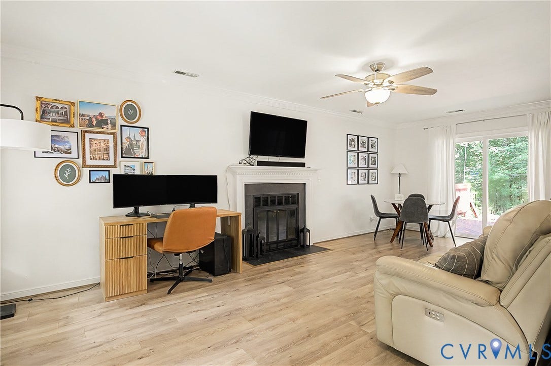 1506 Porters Mill Terrace, Smoketree South, Midlothian, VA 23114 Wood-finish flooring throughout, fireplace with a black iron grate, white mantel, and ceiling fan with integrated lighting
