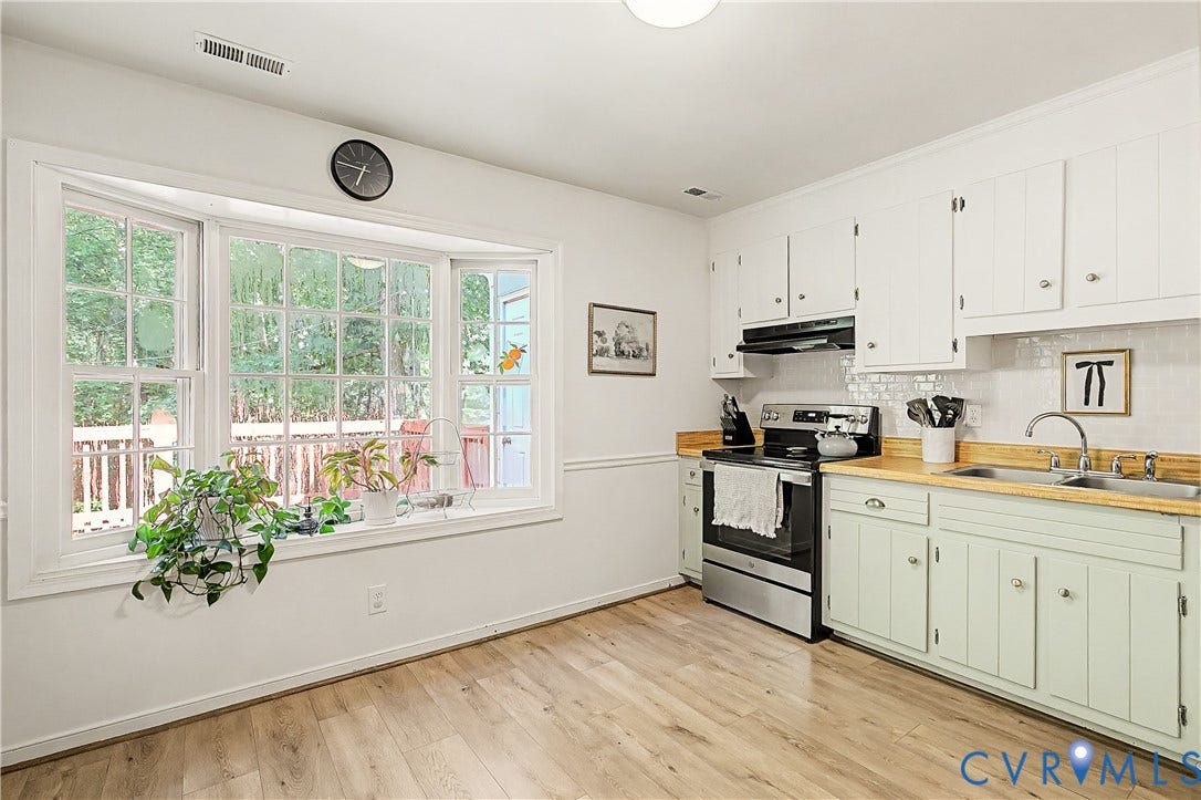1506 Porters Mill Terrace, Smoketree South, Midlothian, VA 23114 Wood-finish flooring, white upper cabinetry, stainless steel range, white tile backsplash, and a multi-pane bay window