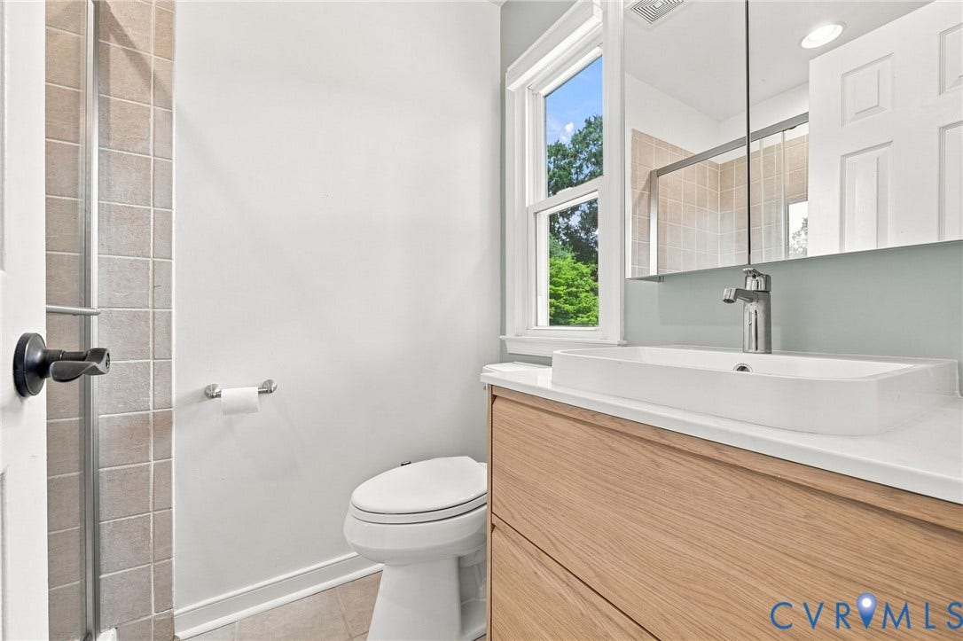 4509 Vienna Woods Place, Innsbrook, Henrico, VA 23060 Modern bathroom featuring a wood-finish vanity with a rectangular vessel sink, contemporary chrome faucet, and a large wall-mounted mirror