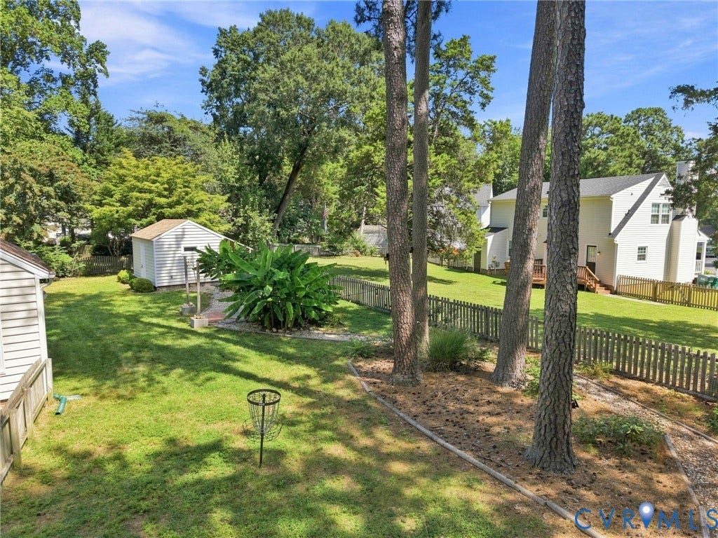 4509 Vienna Woods Place, Innsbrook, Henrico, VA 23060 Expansive sloped yard featuring a privacy fence, mature trees, and a detached storage shed