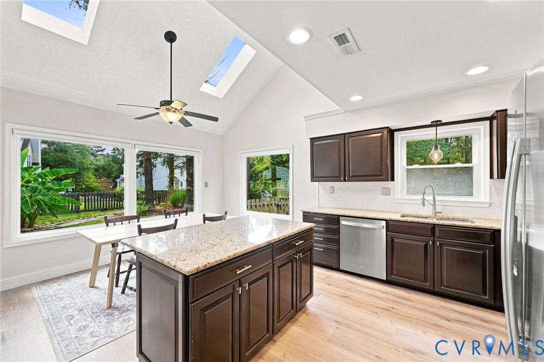 4509 Vienna Woods Place, Innsbrook, Henrico, VA 23060 Vaulted ceiling with skylights, wood-finish flooring, dark wood cabinetry, granite countertops, and stainless steel appliances