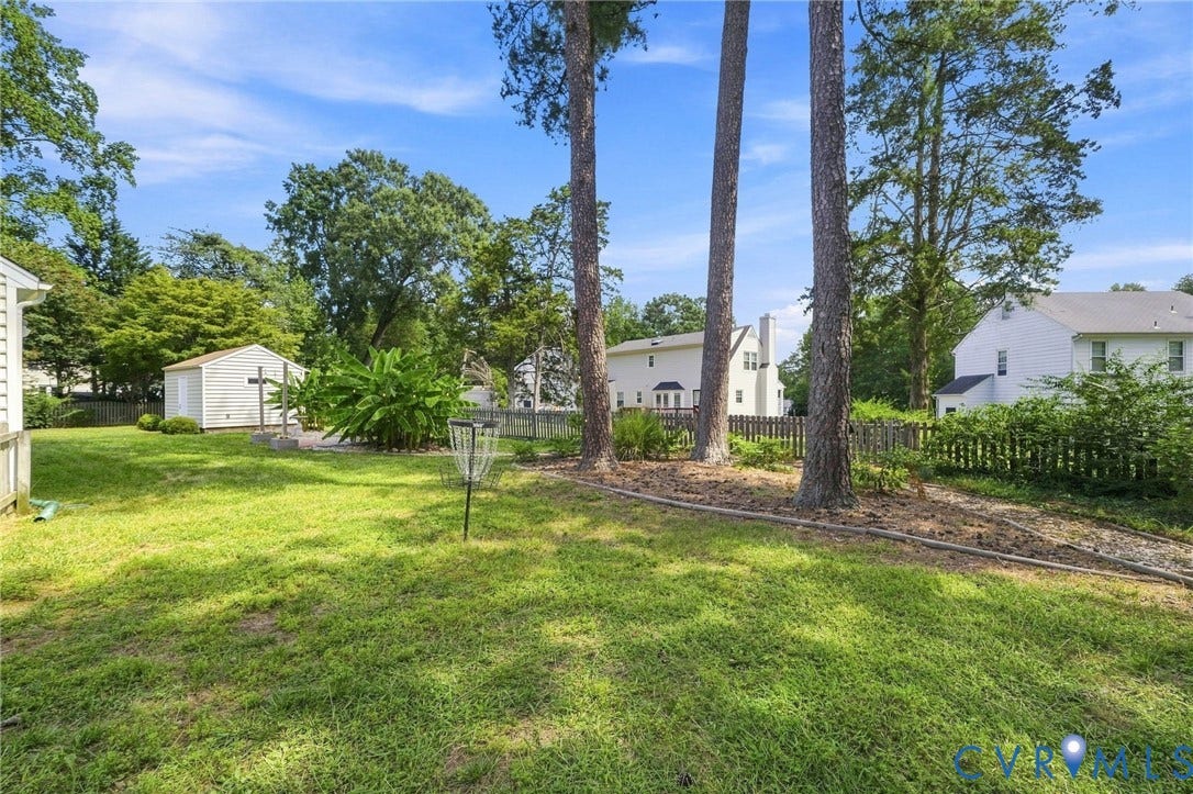 4509 Vienna Woods Place, Innsbrook, Henrico, VA 23060 Expansive green space featuring mature trees, a detached shed, and a privacy fence