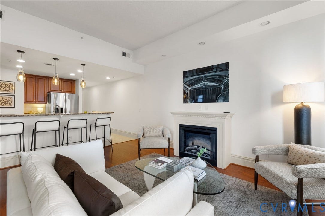 6 N 6th Street, #U5B, Downtown/Financial District, Richmond, VA 23219 Hardwood flooring, a fireplace with a detailed mantel, recessed lighting, and a kitchen bar with pendant lighting