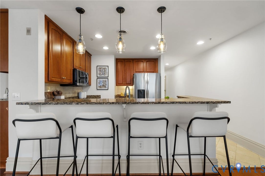 6 N 6th Street, #U5B, Downtown/Financial District, Richmond, VA 23219 Kitchen featuring wood cabinetry, stainless steel appliances, a stone countertop, and pendant lighting