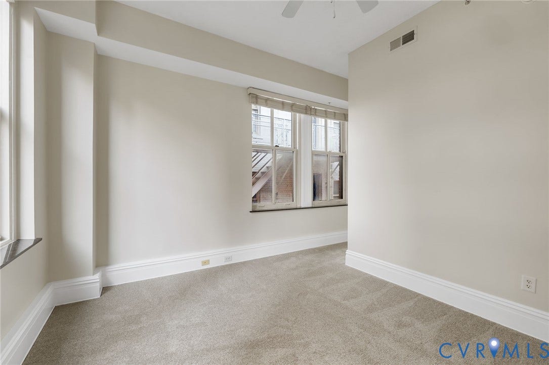 6 N 6th Street, #U5B, Downtown/Financial District, Richmond, VA 23219 Carpeted interior with light-toned walls, multiple windows, classic white trim, and a ceiling fan