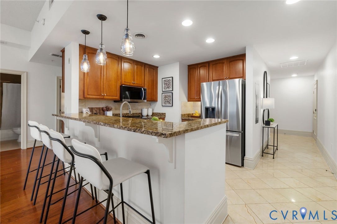 6 N 6th Street, #U5B, Downtown/Financial District, Richmond, VA 23219 Kitchen featuring wood cabinetry, stone countertops, stainless steel appliances, and pendant lighting
