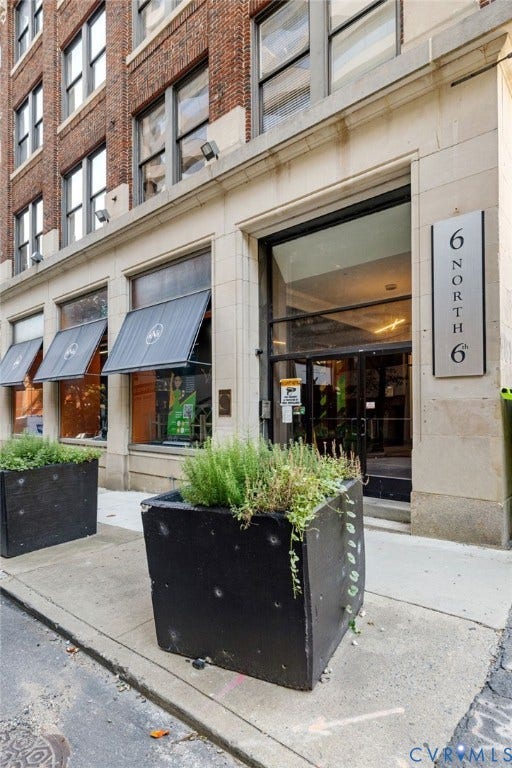6 N 6th Street, #U5B, Downtown/Financial District, Richmond, VA 23219 Brick and stone facade with large storefront windows and awnings, featuring a prominent building signage