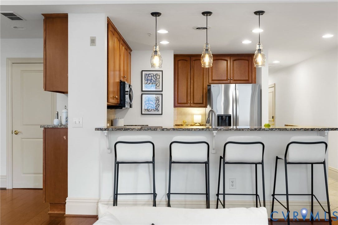 6 N 6th Street, #U5B, Downtown/Financial District, Richmond, VA 23219 Kitchen featuring wood cabinetry, stainless steel refrigerator, and a granite-finish countertop with pendant lighting