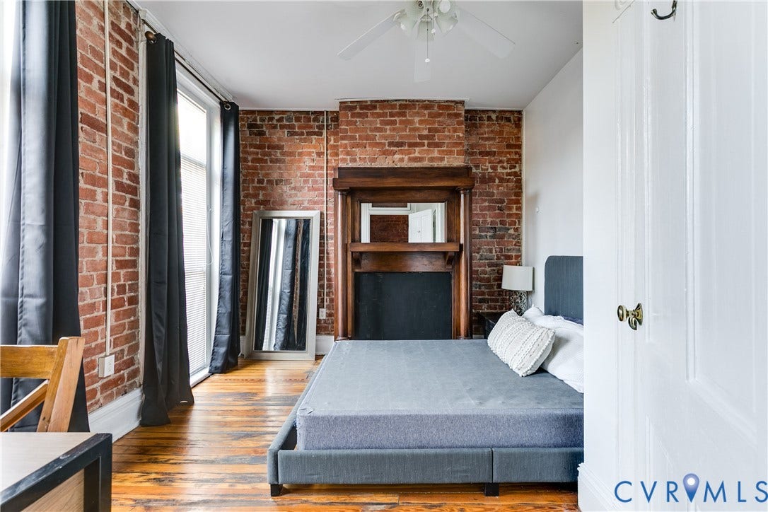 2523 W Main Street, The Fan, Richmond, VA 23220 Exposed brick walls, wood-finish flooring, and a decorative fireplace with a wood mantle and mirror